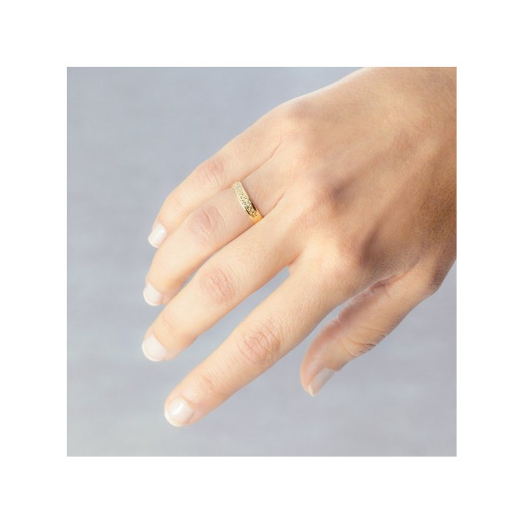 Mano con alianza de boda modelo estrellas de oro 18k amarillo