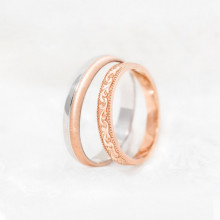 Pareja de anillos de boda en oro rosa y blanco junto a alianza artesanal de oro rosa
