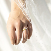 Mano con alianza de boda en oro blanco y amarillo con 3 diamantes
