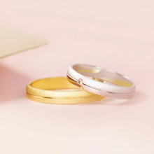 Pareja de anillos de boda con línea central en oro amarillo y blanco con diamante