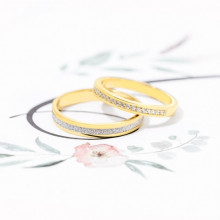Pareja de anillos de boda bicolor diamantada junto a anillo de compromiso