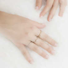 Mano con anillos de compromiso con diamantes distintos colores de oro