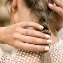Mano de mujer con moderno anillo de doble brazo con dos diamantes