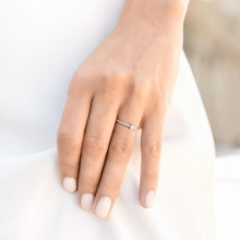 Mano de mujer con anillo trenzado de compromiso en oro blanco