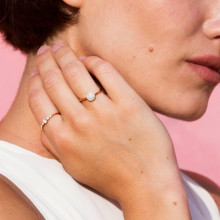 Mano de mujer con dos anillos de compromiso de oro rosa y diamantes
