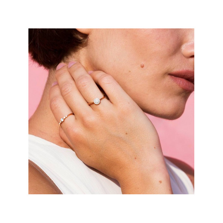 Mano de mujer con dos anillos de compromiso de oro rosa y diamantes