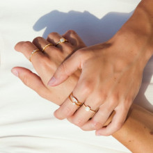 Manos con anillos de diamantes para compromiso en oro amarillo