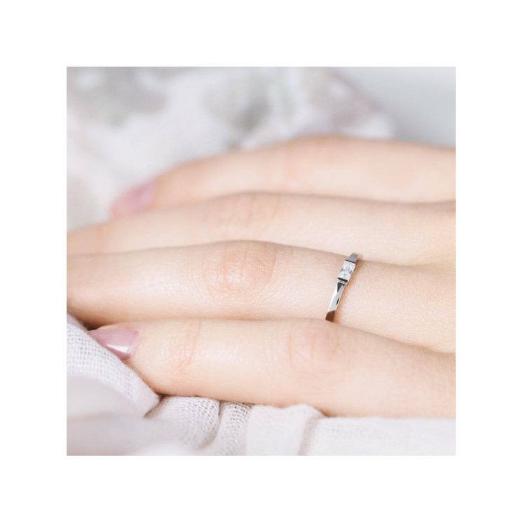 Mano de mujer con anillo fino de pedida con diamante baguette