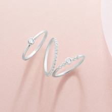 Fondo rosa con anillos finos de compromiso en oro blanco de 18 kilates