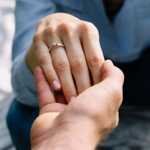 Manos de hombre y mujer con anillo de compromiso de oro 18k blanco y 13 diamantes