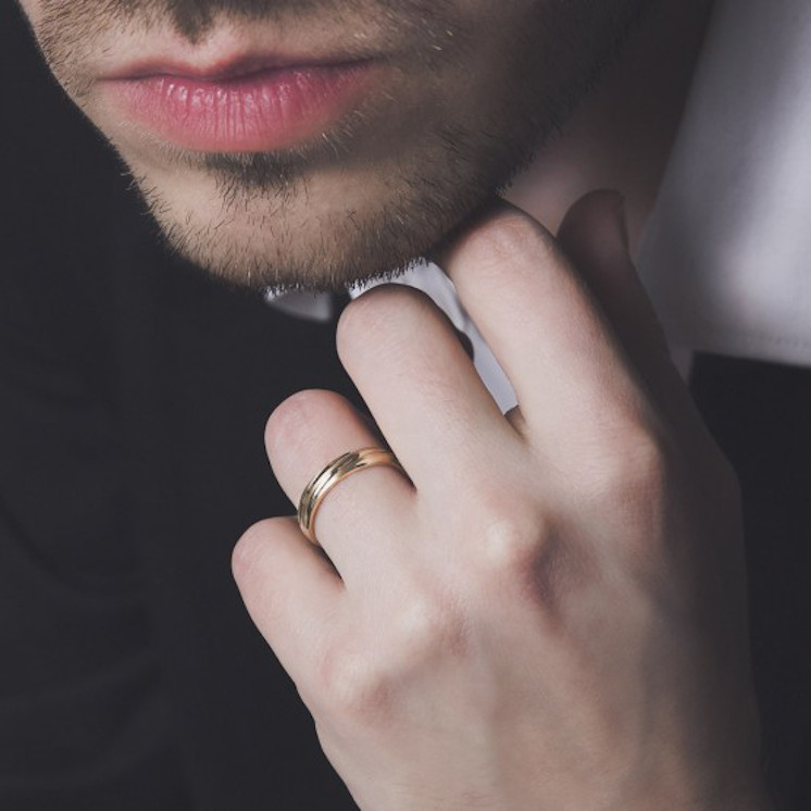 Mano de hombre con alianza de boda torneada de oro amarillo