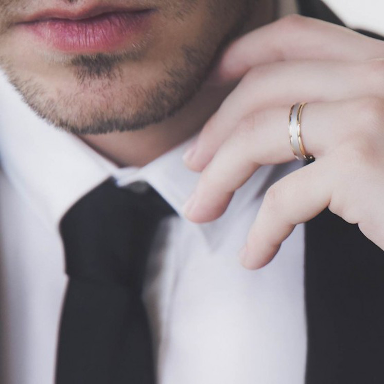 Hombre con alianza de boda en oro amarillo y blanco mate arena