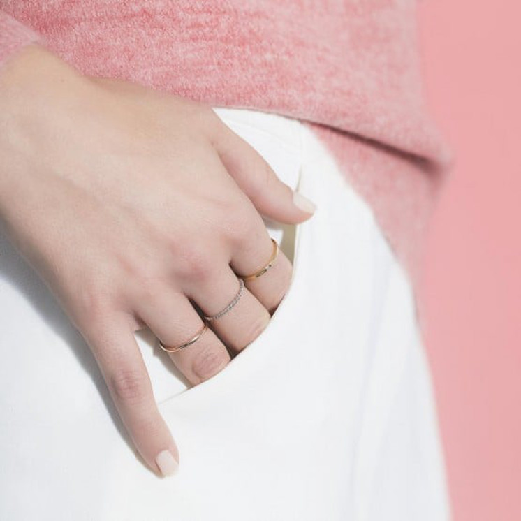 Mano con anillo de matrimonio finos