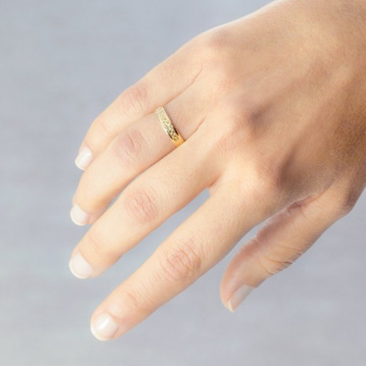 Mano con alianza de boda modelo estrellas de oro 18k amarillo