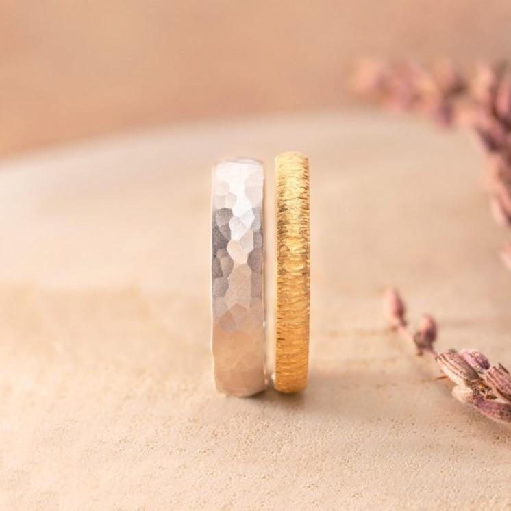 Pareja de anillos de boda en oro blanco y oro amarillo con acabados artesanales