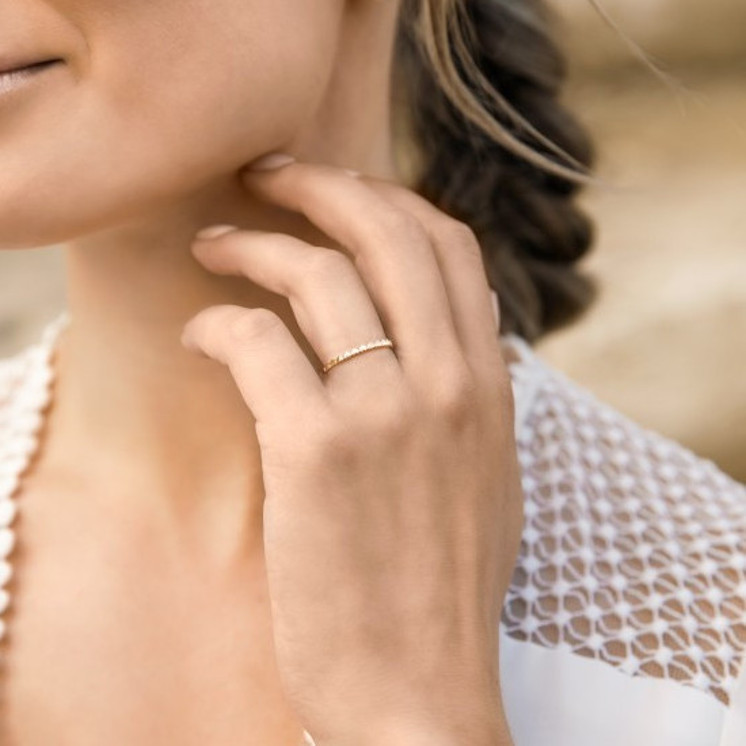 Mano con anillo de matrimonio de oro blanco diseño de corazones