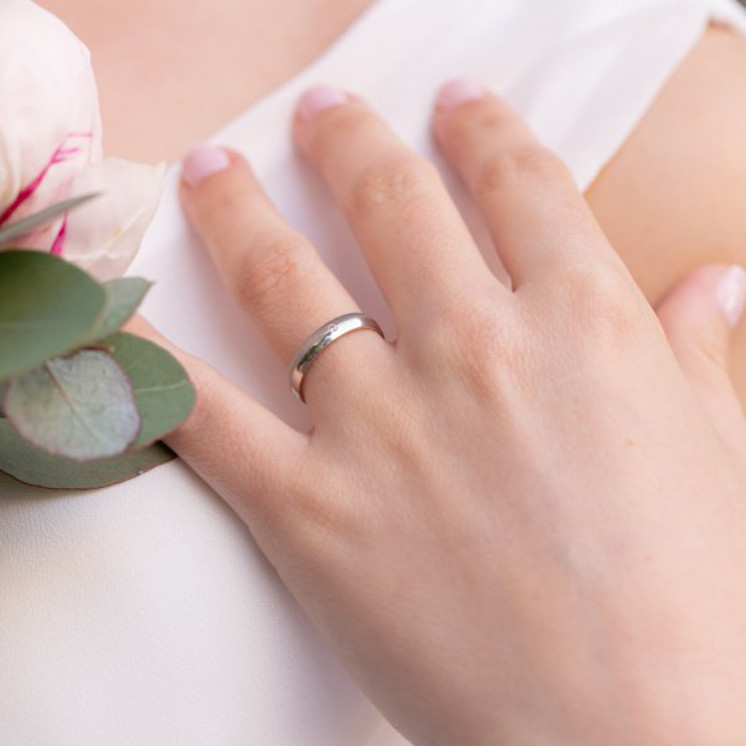 Mano con anillo de boda oro blanco con diamante